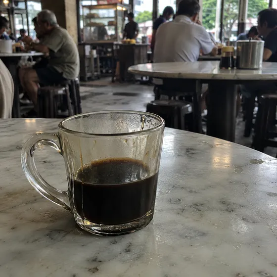 Cawan kopi O hitam atas meja marmar
